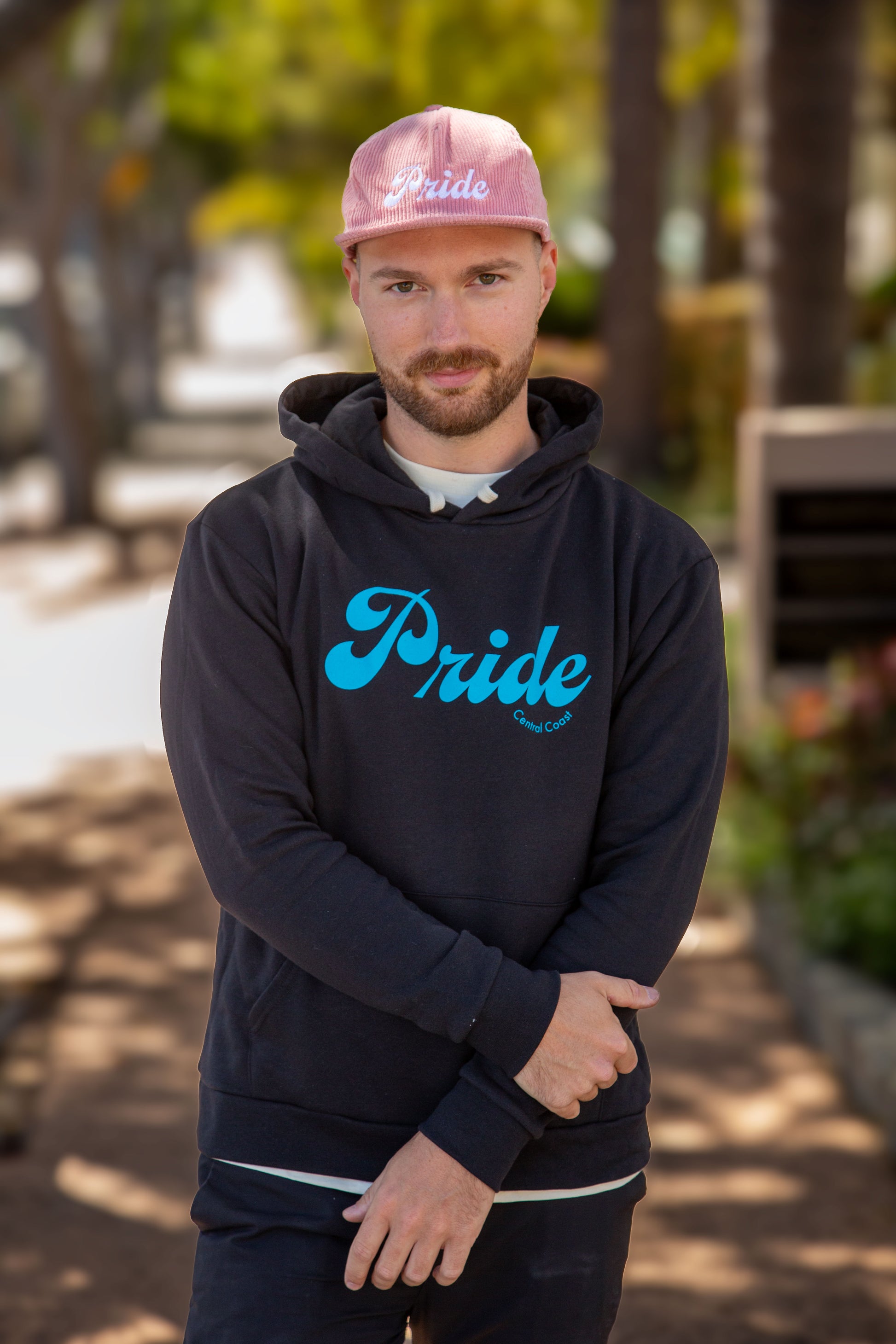 Person wearing the black colored sweater with the text "Pride" and "Central Coast" below in smaller font.