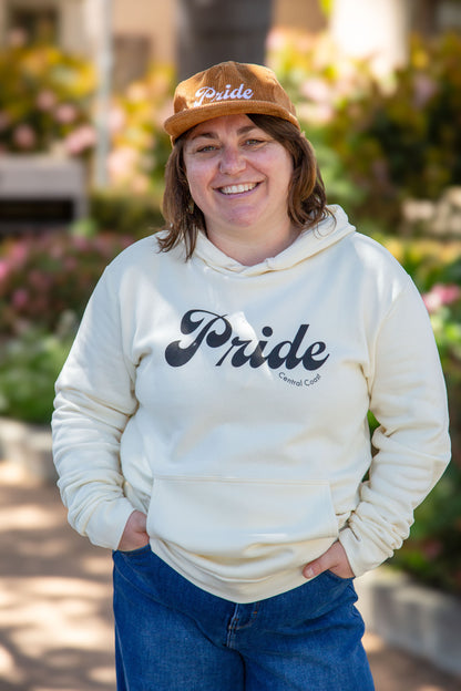 Person wearing the cream colored sweater with the text "Pride" and "Central Coast" below in smaller font.